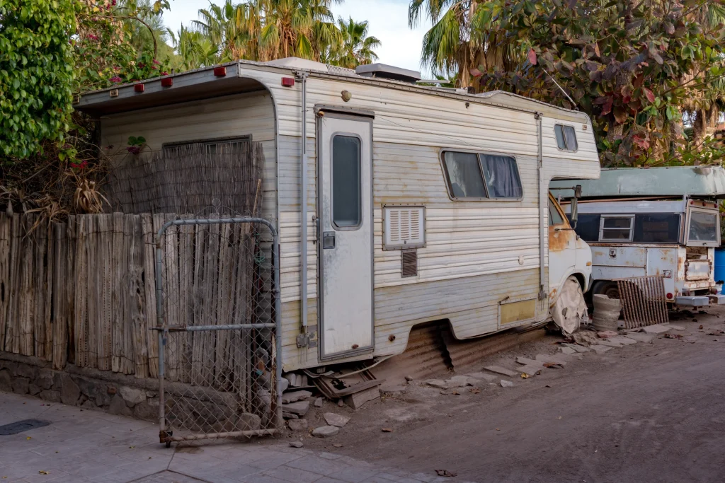 Old or broken RV in a backyard, ready for removal by Pro Junk Dispatch.